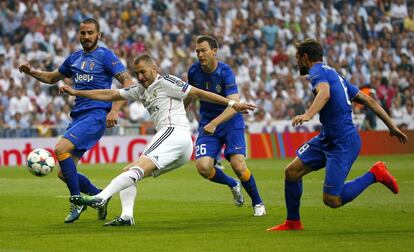 El davanter francès del Reial Madrid Karim Benzemá xuta a porta davant els defenses de la Juventus de Torí Stephan Lichsteiner i Leonardo Bonucci durant el partit de tornada de les semifinals de la Lliga de Campions.