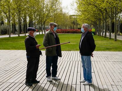 Tres personas conversan a finales de marzo en el Parque Lineal del Manzanares en Madrid.