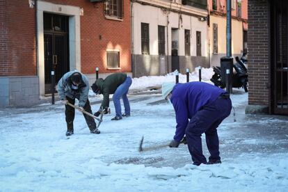 Vecinos de la Avenida del Manzanares quitan el hielo acumulado por la intensa ola de frío, este martes en Madrid.