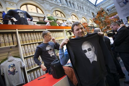 Un hombre sostiene una sudadera con una imagen del presidente ruso Vladimir Putin en GUM (la tienda departamental de estado) en Moscú, el 6 de octubre de 2014.