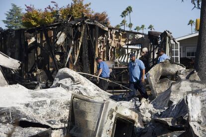 Oficiales inspeccionan los alrededores de una casa mvil destrozada por un incendio de gas, producido por el terremoto en California.