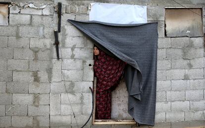 Una mujer palestina se asoma por la puerta de su casa, en Khan Younis, en el sur de la Franja de Gaza.