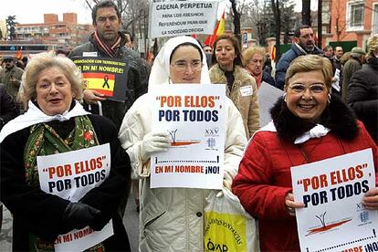 Varias personas, entre ellas una religiosa, portan el cartel de la convocatoria oficial de la manifestación que ha transcurrido por las calles de Madrid.