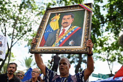 Un seguidor de Maduro acude al mitin con una pintura del presidente. 