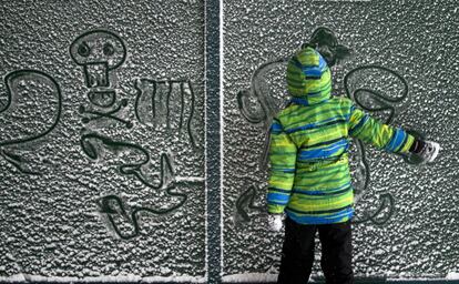 Un niño hace dibujos en la nieve en Bucarest (Rumanía), el 17 de enero 2016.