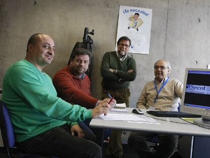 Daniel Escrig, de pie, junto a Manuel Robles (derecha), atendiendo a dos <i>clientes</i>.