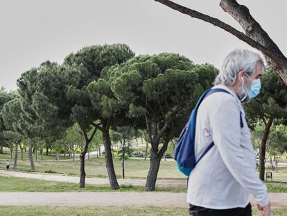 Un hombre con mascarilla pasea por el parque de San Isidro, uno de los parques reabiertos en la capital.