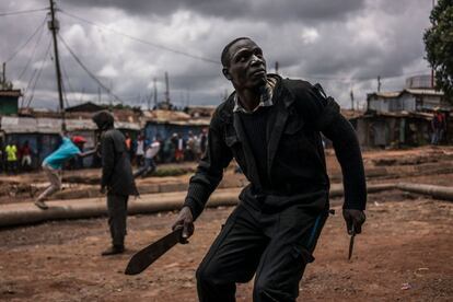 Un manifestante se enfrenta a la policía con un machete y un cuchillo durante las protestas en el barrio de Kibera, Nairobi.
