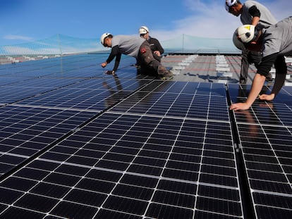 Montaje de estructuras de placas solares en el tejado de una industria.