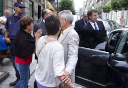 Dos afectadas por las preferentes se dirigen al presidente de la Xunta de Galicia, Alberto Núñez Feijóo (d), a su la salida de la IV Conferencia Mundial de las conservas de pescados y mariscos que se celebra en Vigo.