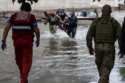 Emergency teams help rush to safety injured civilian evacuees who had came under fire from Russian forces while trying to flee by boat from the Russian-occupied east bank of a flooded Dnieper River to Ukrainian-held Kherson