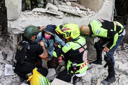 Equipes de resgate retiram um morador dos escombros de um prédio de apartamentos atingido por um ataque iraniano em Tel Aviv no domingo.