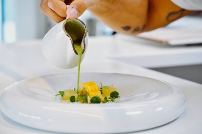 Sopa de hierbas silvestres con crema de queso, pera confitada y millo.