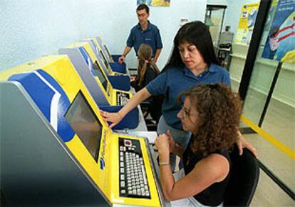 Trabajadores de la oficina postal, situada en Arganzuela, atienden a unas usuarias.