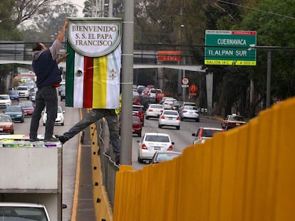 Trabajadores de la Ciudad cuelgan estandartes de bienvenida al Papa.