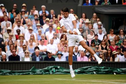 Djokovic golpea la pelota para devolvérsela a Federer.