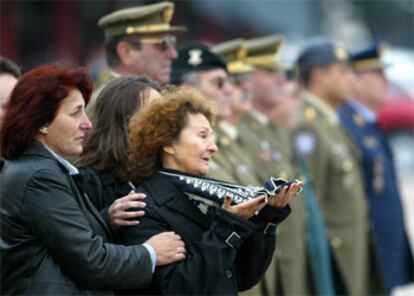 La madre y las hermanas de Luis Puga, fallecido el pasado domingo en Base España, reciben el féretro.