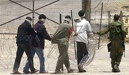 Un soldado israelí conduce a un grupo de palestinos maniatados y con los ojos vendados por una base militar en la ciudad cisjordana de Hebrón.
