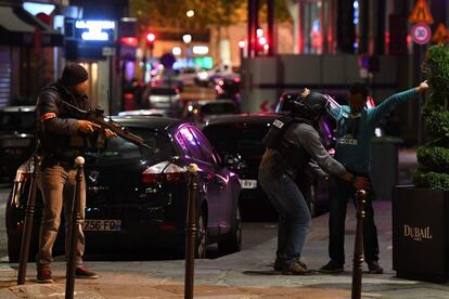 Los agentes de policía registran a un hombre cerca de los Campos Elíseos en París.