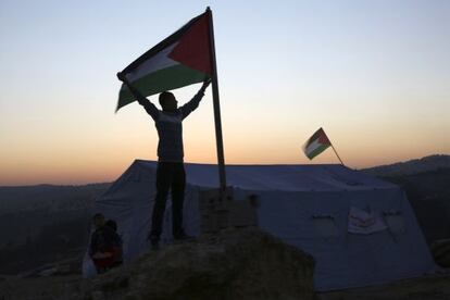 Un activista alza una bandera palestina en el campamento de Beit Iksa, cerca de Ramala.