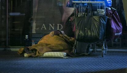 Un sin techo duerme en una calle del distrio de L'Eixample.