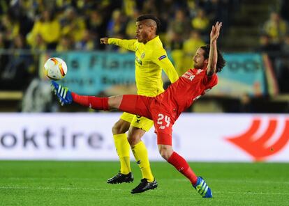 Joe Allen del Liverpool extiende la pierna para golpear el balón frente a Jonathan dos Santos del Villlarreal.