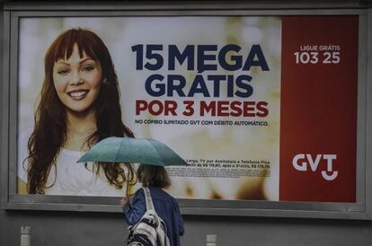 Una mujer pasa ante una publicidad de GVT, en R&iacute;o.