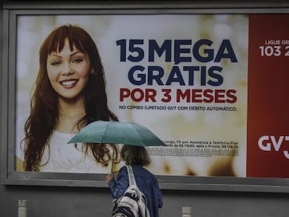 Una mujer pasa ante una publicidad de GVT, en R&iacute;o.