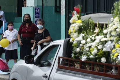 Habitantes de Ciudad Delgado observan mientras un coche fúnebre traslada los restos de los migrantes fallecidos al cementerio de la localidad.