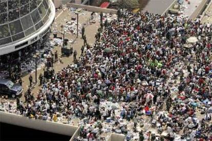 Centenares de personas aguardan la llegada de autobuses en el Superdome.