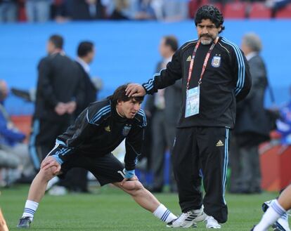 El entonces seleccionador de Argentina, Diego Armando Maradona (a la derecha), toca la cabeza de Lionel Messi durante el calentamiento antes del partido del Grupo B contra Nigeria en el Mundial de Fútbol de Sudáfrica, en junio de 2010.