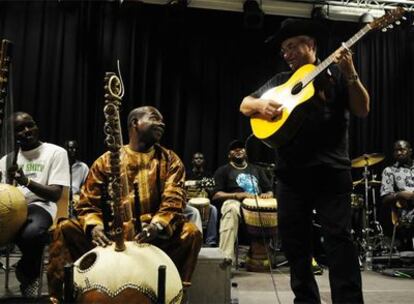 El músico de Malí Toumani Diabaté (izquierda), con su kora, charla con el cubano Eliades Ochoa durante un ensayo previo al concierto del domingo en Zaragoza. 
/ c. anguila
Escenas entre bambalinas del concierto del domingo en Zaragoza. A la izquierda, Damon Albarn, de Blur, y sobre estas líneas, Sorderita y Diabaté, durante la prueba de sonido.