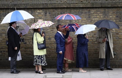 Varias personas hacen cola para asistir a la Royal Garden Party en el palacio de Buckingham en Londres.