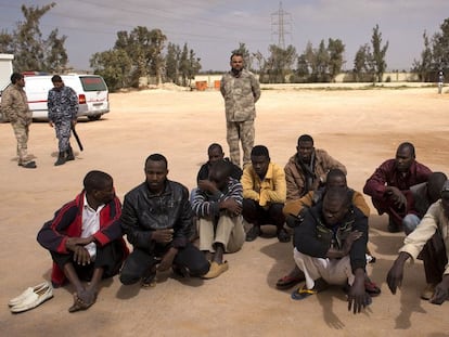 Un grupo de inmigrantes es custodiado junto a un centro de internamiento para extranjeros en Misrata.