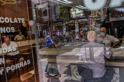 Un camarero atiende con mascarilla en un bar de Vallecas.