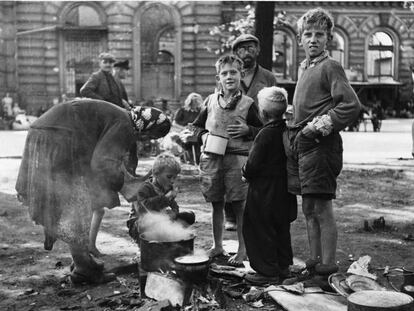 Una madre alemana cocina para su familia en una calle del Berlín de 1945