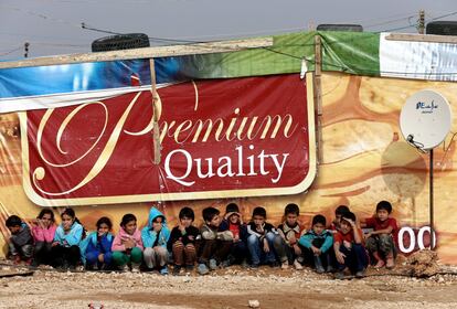 FILE - In this Dec. 2, 2014, file Photo, Syrian refugee children, sit near a tent at the entrance of their refugee camp as they wait to attend an activity, in the eastern Lebanese Town of Al-Faour near the border with Syria, Lebanon. UNICEF said Monday, March 14, 2016 that one-third of Syrians under the age of 18, or about 3.7 million, were born since an uprising against President Bashar Assad erupted in 2011 and escalated into a civil war. (AP Photo/Hussein Malla, File)