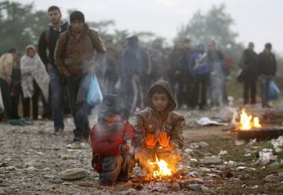 Dos niños se calientan junto a una hoguera cerca de la ciudad de Gevgelija (Macedonia), en la frontera con Grecia.