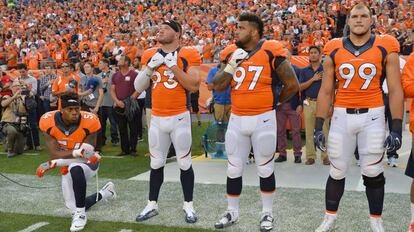 Brandon Marshall, defensa de los Denver Broncos, se arrodilla ante el himno nacional en se&ntilde;al de protesta.