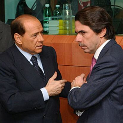 El presidente del Gobierno italiano, Silvio Berlusconi, habla con José María Aznar en un momento de la cumbre.