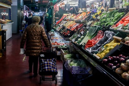 Una mujer hace su compra de Navidad en el Mercado de La Cebada, en La Latina.