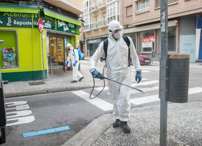 Empleados municipales del servicio de limpieza desinfectan una calle de Zaragoza, este jueves, como medida preventiva contra el coronavirus.