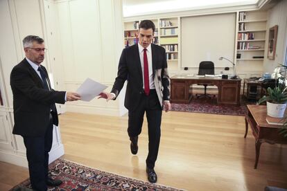 El presidente del Gobierno, Pedro Sánchez, recoge información saliendo de un despacho, previo a la entrevista.