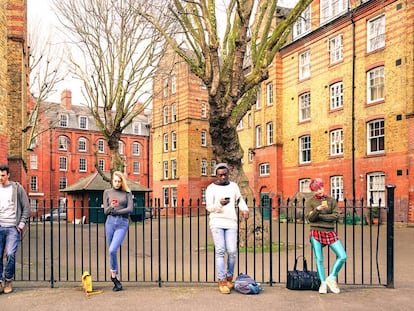 Jóvenes de distintas razas miran sus smartphones en Londres. 