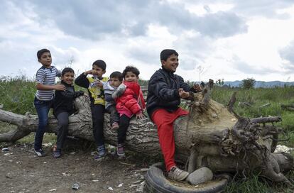 Algumas crianças refugiadas brincam enquanto esperam a permissão para entrar no campo de registro depois de cruzar a fronteira entre a Grécia e a Macedônia, perto da cidade de Gevgelija, Macedônia, em 20 de outubro de 2015. Cerca de 10.000 refugiados entraram na Macedônia através da fronteira grega no fim de semana anterior, de acordo com a polícia do país. O elevado fluxo de pessoas, principalmente sírios e afegãos, levou a fechamentos ocasionais das fronteiras deste país.