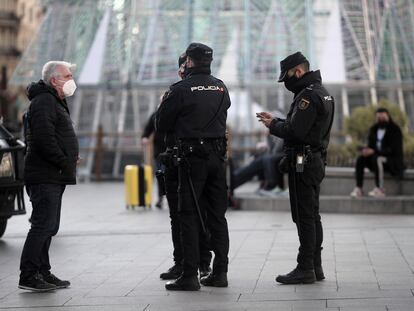 Un hombre habla con varios policías nacionales en la Puerta del Sol, en Madrid (España), a 30 de diciembre de 2020.