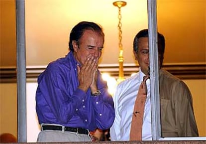 Carlos Menem saluda a sus seguidores, esta noche, desde una ventana del Hotel Presidente.