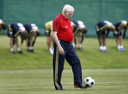 Luis Aragonés da toques a un balón mientras sus jugadores se ejercitan al fondo en el entrenamiento de ayer.