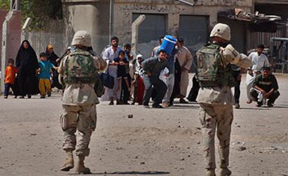 Soldados de EE UU apuntan con sus armas a un grupo de civiles de Nayaf que huyen de sus casas para intentar ponerse a salvo de los combates.