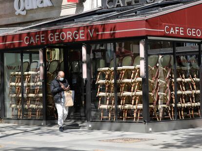 Un hombre, frente a un café cerrado en París.